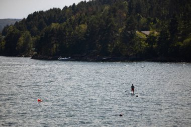 Iskar Reservoir Bulgaristan 'da bir raket pansiyoneri. Güzel doğa. Dağların altındaki suyun üstündeki kişi. Yüksek kalite fotoğraf