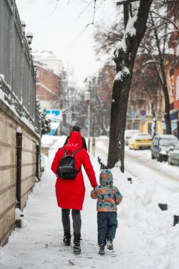 Bulgaristan, Şubat 2021: Sofya, Bulgaristan ve Avrupa 'nın karlı sokaklarında yürüyen renkli bir anne ve çocuk. Yüksek kalite fotoğraf
