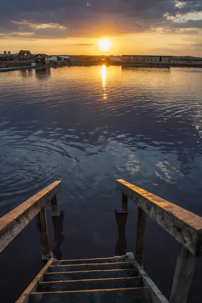 stock image A wooden pier next to a body of water at sunset. High quality photo