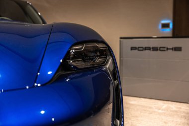 Circa 2023 - Sofya, Bulgaristan: Bir konferans odasında mavi, parlak, yeni bir Porsche Tacan arabası sergileniyor. Yüksek kalite fotoğraf