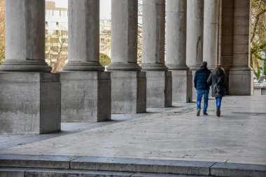 Solunda sütunlar olan eski bir binanın ortasında yürüyen bir çift. Brüksel 'de romantik bir çift kaçamağı. Yüksek kalite fotoğraf