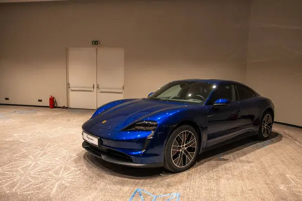 Stock image Circa 2023 - Sofia, Bulgaria: A blue shiny new Porsche Tacan car on display on a conference room. High quality photo