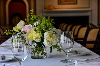 Masaya boş su bardakları ve çiçekli vazo. Süslü bir masanın yüksek kaliteli fotoğrafı.