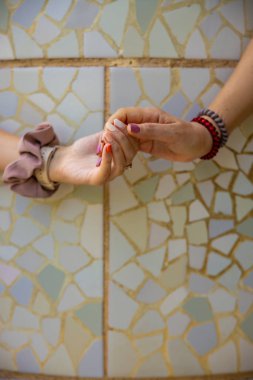 Barcelona, İspanya 'da Gaudi' nin Mozaik Park Guell 'ini elinde tutan iki kadın el. Anne, kız en iyi arkadaş kavramı. Yüksek kalite fotoğraf