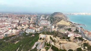 Alicante, İspanya 'nın çarpıcı hava aracı görüntüsü, Santa Brbara Şatosu, şehrin ufuk çizgisi ve Akdeniz kıyılarını gösteriyor. Seyahat, emlak ve turizm projeleri için ideal.