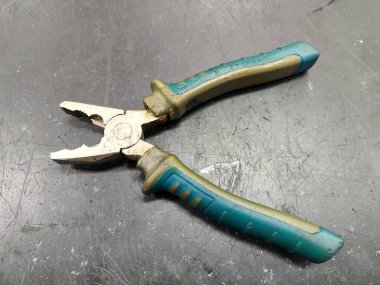 Kazınmış metal bir yüzeyde eski pense, fotoğrafa yakın çekim.