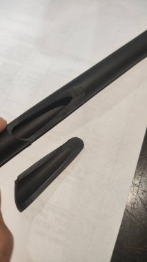 Siyah arka planı olan siyah beyaz kauçuk bir borunun yakın çekimi.