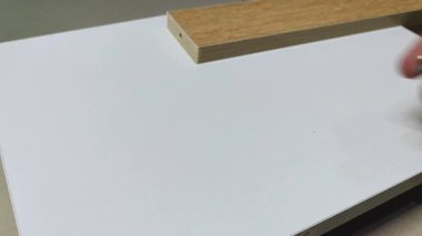 Bir adamın eli, beyaz tahtanın üstüne üç tane sivri vida yerleştiriyor ve vidalardan biri düşüyor. Reklam endüstrisi ve imalat için klip