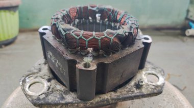 Eski ve paslı dinamonun içi, çamaşır makinesinin dinamo dinamo dinamosu üzerinde bir bobin gibidir.