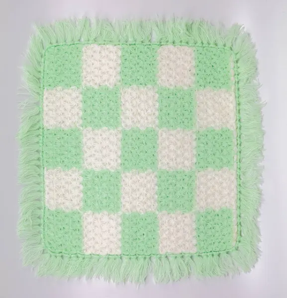 stock image Handmade Crocheted Checkered Mat in Light Green and White with Fringe