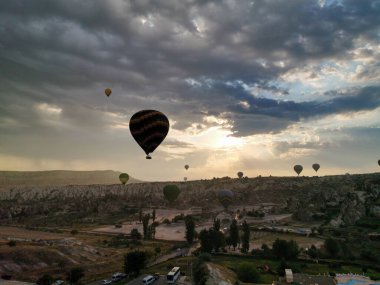 Güneş doğarken sıcak hava balonları kapadokçaların üzerinde eşsiz bir manzara