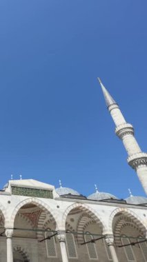 Süleyman Camii 'nin girişi boyunca itin, arka planda gün ortasında yüksek kuleler