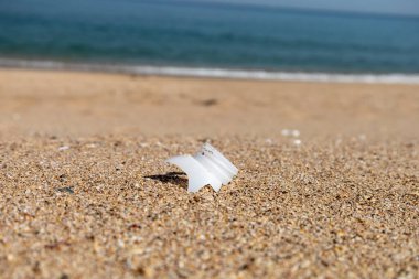 Plastik şişe ve plajın kapağını yakın plan çek. Dünyayı kurtarıyorum. Çevre ekoloji bakımı ve yenilenebilir enerji kavramı. Kumsal ve kum, çöp, temizlik.