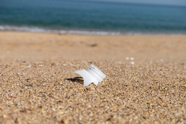 Plastik şişe ve plajın kapağını yakın plan çek. Dünyayı kurtarıyorum. Çevre ekoloji bakımı ve yenilenebilir enerji kavramı. Kumsal ve kum, çöp, temizlik.