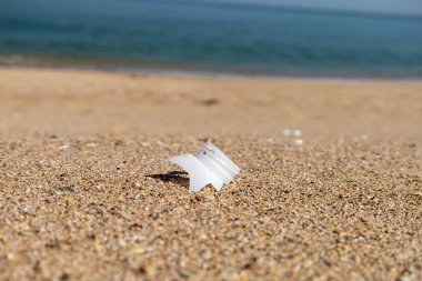 Plastik şişe ve plajın kapağını yakın plan çek. Dünyayı kurtarıyorum. Çevre ekoloji bakımı ve yenilenebilir enerji kavramı. Kumsal ve kum, çöp, temizlik.