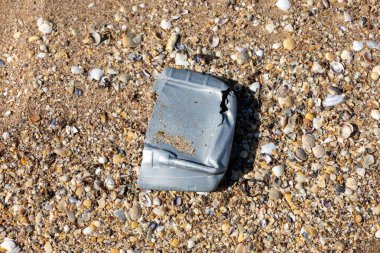 Plastik şişe ve plajın kapağını yakın plan çek. Dünyayı kurtarıyorum. Çevre ekoloji bakımı ve yenilenebilir enerji kavramı. Kumsal ve kum, çöp, temizlik.