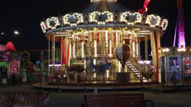 Geceleri dönme dolap. Gece bir lunaparktan gelen bulanık, renkli ışıklar. Gece dönme dolap dönüyor..