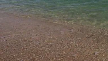 Akdeniz 'in dalgaları kumlu plaja doğru gün ışığında akıyor. Güzel Türk doğası. Sakinleştirici köpüklü suyun yakın plan çekimi.