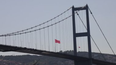 Üzerinde kırmızı bayrak sallanan büyük bir köprü. Bayrak özgürlük ve bağımsızlığın sembolüdür.