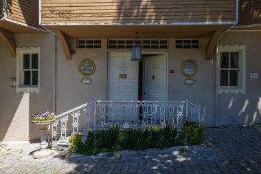 İstanbul Kütüphanesi girişi: beyaz kapı, süslü korkuluk, bitkiler.