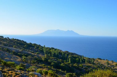 Yazın bir sahil tepesinden uzak volkanik ada manzarası