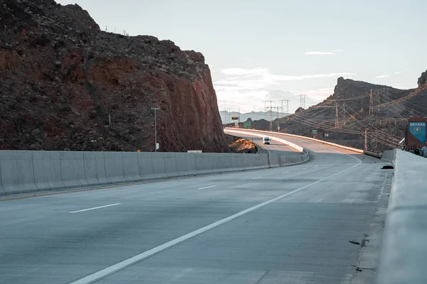 Diminishing Perspective Of Arch Bridge road By Mountain At Hoover Dam In Nevada During Sunset
