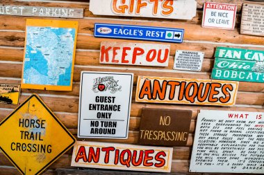 Yellowstone Ulusal Parkı, ABD. 16 Eylül 2022. Restorandaki ahşap duvarda yazı olan çeşitli tabelalar. Ünlü Yellowstone Ulusal Parkı 'ndaki otelde dekorasyon..