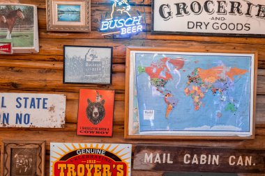 Yellowstone Ulusal Parkı, ABD. 16 Eylül 2022. Restorandaki ahşap duvarda çeşitli panoların asılı olduğu dünya haritası. Yellowstone Milli Parkı 'ndaki otelin eşsiz dekorasyonu..