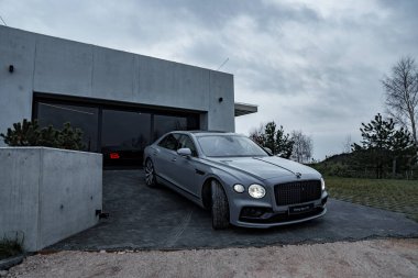 2022 Bentley Uçan Mahmuz V12. Üçüncü kuşak Flying Spur özel villaya yakın çekim yapıyor.. 