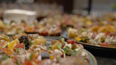 Siyah taş tabaklar üzerinde güzel kanepeler. Büfe masası. Sinema videosunda yemek servisi.