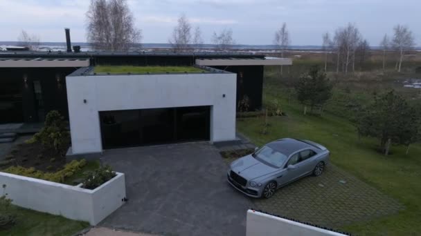 豪华汽车停泊在城外的现代私人别墅里 宾利飞艇V12 Bentley Flying Spur V12 停放在旁边的豪华2022年私人住宅的空中视频 — 图库视频影像