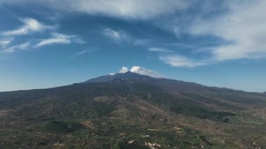 Etna yanardağının geniş panoramik görüntüsü, yokuştaki sönmüş kraterler, volkanik aktivite izleri.