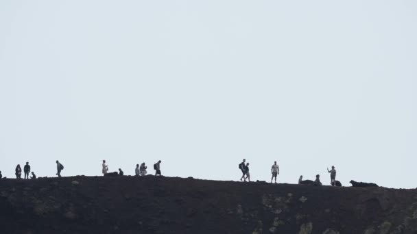 火山エトナ山をハイキングする観光客 有名な場所で冒険的な休暇を楽しんでいる人々 背景に煙に覆われた空と劇的な風景のビュー Etna — ストック動画