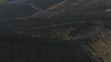 Etna yanardağının geniş panoramik görüntüsü, yokuştaki sönmüş kraterler, volkanik aktivite izleri.