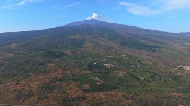 Etna yanardağının geniş panoramik görüntüsü, yokuştaki sönmüş kraterler, volkanik aktivite izleri.