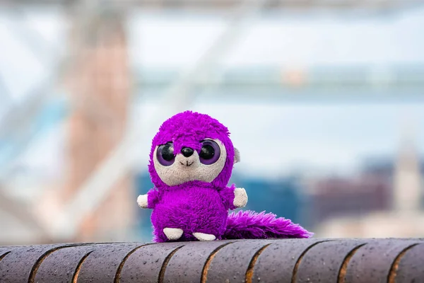 Fluffy cute toy exploring London, UK near the tower bridge.