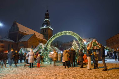 İnsanlar kışın Letonya 'da Noel pazarını seviyor Riga. Sihirli Avrupa Noel pazarı.