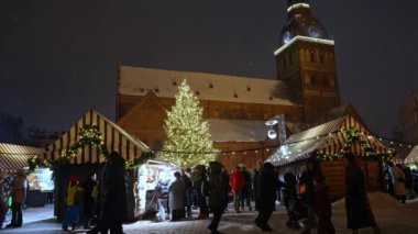 İnsanlar kışın Letonya 'da Noel pazarını seviyor Riga. Sihirli Avrupa Noel pazarı.