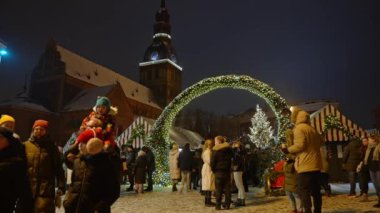 İnsanlar kışın Letonya 'da Noel pazarını seviyor Riga. Sihirli Avrupa Noel pazarı.