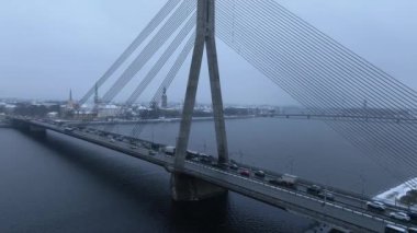 Riga şehri üzerinde bulutlu ve karlı bir kış. Kış Riga 'da, Daugava nehrinin karşısındaki köprüden..