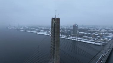 Riga şehri üzerinde bulutlu ve karlı bir kış. Kış Riga 'da, Daugava nehrinin karşısındaki köprüden..