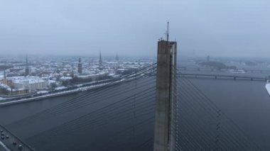 Riga şehri üzerinde bulutlu ve karlı bir kış. Kış Riga 'da, Daugava nehrinin karşısındaki köprüden..