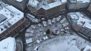 Riga şehri üzerinde bulutlu ve karlı bir kış. Riga 'da kış, eski şehrin merkezindeki Noel pazarına yakın bir yerden..