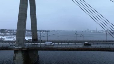 Riga şehri üzerinde bulutlu ve karlı bir kış. Kış Riga 'da, Daugava nehrinin karşısındaki köprüden..