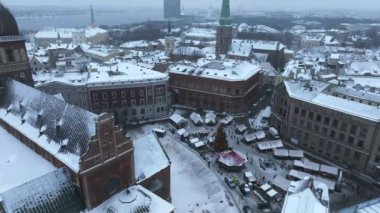 Riga şehri üzerinde bulutlu ve karlı bir kış. Riga 'da kış, eski şehrin merkezindeki Noel pazarına yakın bir yerden..