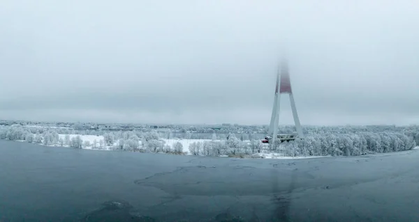 Aerial drone top view of the Riga TV Tower in Latvia. Highest TV tower in Europe over the clouds.
