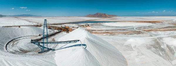 Salt Lake City, Utah landscape with desert salt mining factory at lake Bonneville with piles of white mineral and industrial equipment