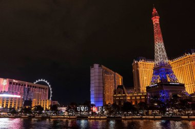 Las Vegas, ABD. 16 Eylül 2022. Aydınlatılmış Eyfel kulesinin ve gezinti alanındaki lüks otellerin kopyası. Gece karanlığında gökyüzü olan güzel Las Vegas şehri manzarası.