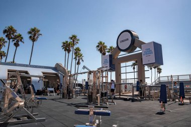 Los Angeles, ABD. 20 Eylül 2022. Güneşli bir günde arka planda açık mavi gökyüzü olan Muscle Sahili 'ndeki açık jimnastik salonunda çeşitli halter egzersiz ekipmanları.