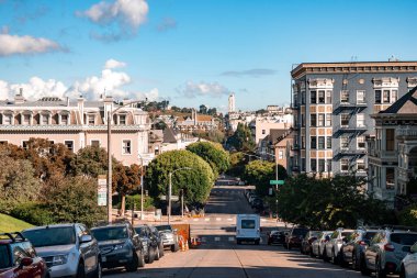 San Francisco, ABD. 20 Eylül 2022. Arabalar sokağa park edilmişti. Arka planda mavi gökyüzü olan Boyalı Kadınlar binaları Kaliforniya 'daki Alamo Meydanı' nda.